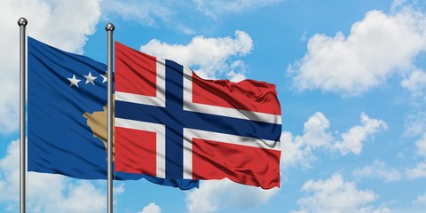 Kosovo and Norway flag waving in the wind against white cloudy blue sky together. Diplomacy concept, international relations.