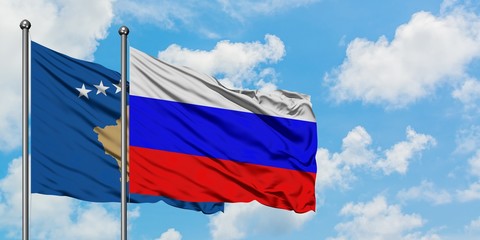 Kosovo and Russia flag waving in the wind against white cloudy blue sky together. Diplomacy concept, international relations.