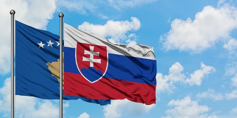 Kosovo and Slovakia flag waving in the wind against white cloudy blue sky together. Diplomacy concept, international relations.