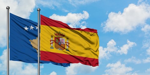 Kosovo and Spain flag waving in the wind against white cloudy blue sky together. Diplomacy concept, international relations.