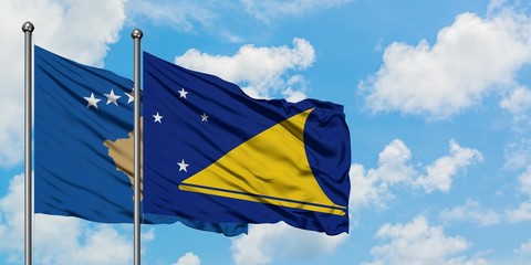 Kosovo and Tokelau flag waving in the wind against white cloudy blue sky together. Diplomacy concept, international relations.
