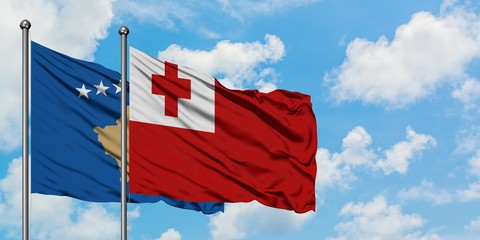 Kosovo and Tonga flag waving in the wind against white cloudy blue sky together. Diplomacy concept, international relations.