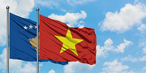 Kosovo and Vietnam flag waving in the wind against white cloudy blue sky together. Diplomacy concept, international relations.