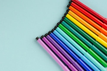 Colored felt tip pens composition on blue background.