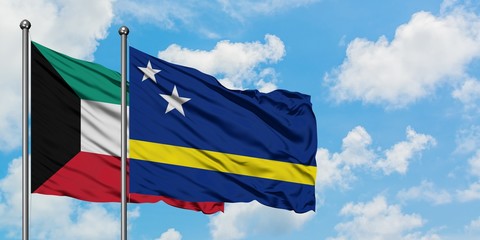 Kuwait and Curacao flag waving in the wind against white cloudy blue sky together. Diplomacy concept, international relations.