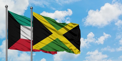 Kuwait and Jamaica flag waving in the wind against white cloudy blue sky together. Diplomacy concept, international relations.