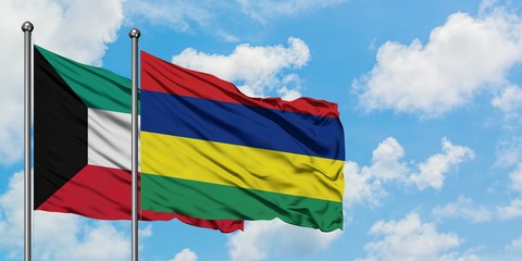 Kuwait and Mauritius flag waving in the wind against white cloudy blue sky together. Diplomacy concept, international relations.
