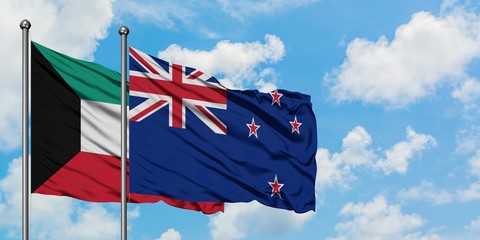 Kuwait and New Zealand flag waving in the wind against white cloudy blue sky together. Diplomacy...