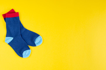 Cotton kids socks composition on yellow background.