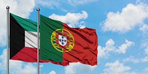 Kuwait and Portugal flag waving in the wind against white cloudy blue sky together. Diplomacy concept, international relations.