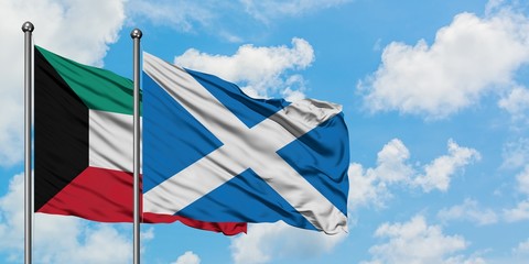 Kuwait and Scotland flag waving in the wind against white cloudy blue sky together. Diplomacy concept, international relations.