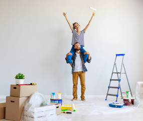 young happy couple is repairing and painting   wall at home.
