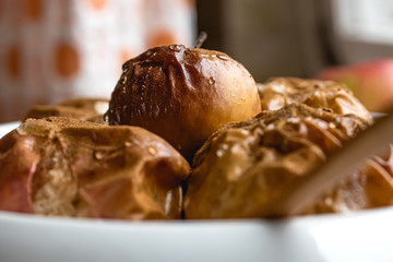Baked apples, sprinkled with cinnamon and honey in a ceramic dish