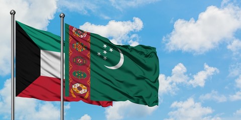 Kuwait and Turkmenistan flag waving in the wind against white cloudy blue sky together. Diplomacy...