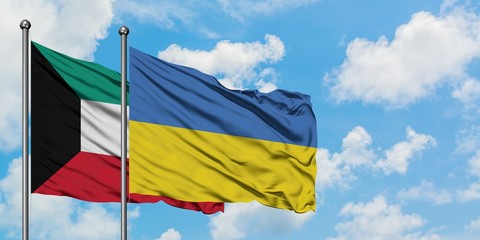 Kuwait and Ukraine flag waving in the wind against white cloudy blue sky together. Diplomacy concept, international relations.