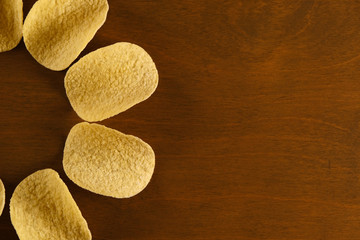 half sun or flower shaped potato chips on wooden table, top view with copy space for text and design for fast food restaurant menu