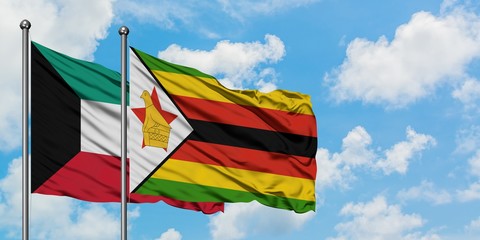 Kuwait and Zimbabwe flag waving in the wind against white cloudy blue sky together. Diplomacy concept, international relations.