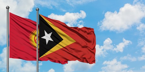 Kyrgyzstan and East Timor flag waving in the wind against white cloudy blue sky together. Diplomacy concept, international relations.