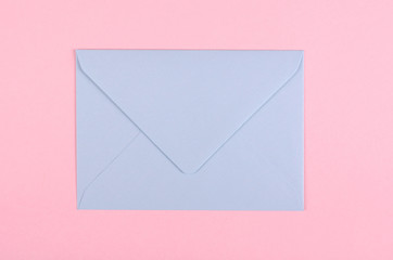 Blue paper envelope composition on pink background.