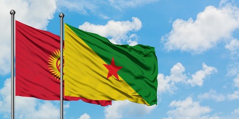 Kyrgyzstan and French Guiana flag waving in the wind against white cloudy blue sky together. Diplomacy concept, international relations.