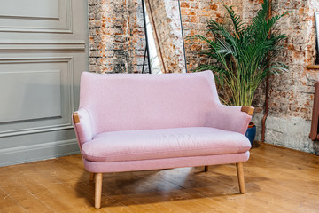 vintage pink sofa with wooden legs