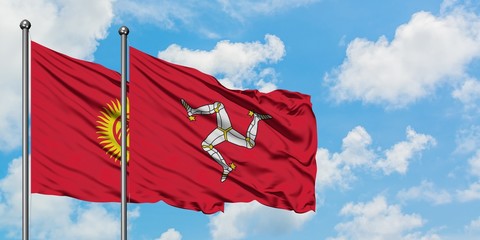 Kyrgyzstan and Isle Of Man flag waving in the wind against white cloudy blue sky together. Diplomacy concept, international relations.