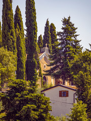Fototapeta premium Vistas de una iglesia entre árboles en Groznjan , península de Istria, Croacia, verano de 2019