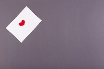 Paper envelope with red heart composition on dark background.