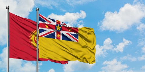 Kyrgyzstan and Niue flag waving in the wind against white cloudy blue sky together. Diplomacy concept, international relations.