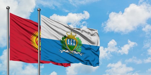 Kyrgyzstan and San Marino flag waving in the wind against white cloudy blue sky together. Diplomacy concept, international relations.