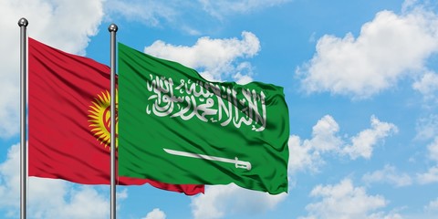 Kyrgyzstan and Saudi Arabia flag waving in the wind against white cloudy blue sky together. Diplomacy concept, international relations.