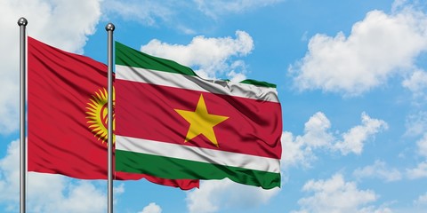 Kyrgyzstan and Suriname flag waving in the wind against white cloudy blue sky together. Diplomacy concept, international relations.