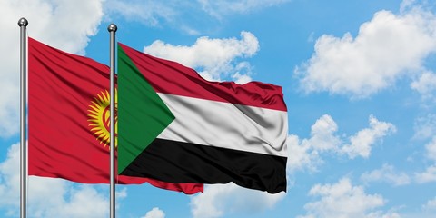 Kyrgyzstan and Sudan flag waving in the wind against white cloudy blue sky together. Diplomacy...