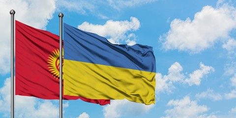 Kyrgyzstan and Ukraine flag waving in the wind against white cloudy blue sky together. Diplomacy concept, international relations.
