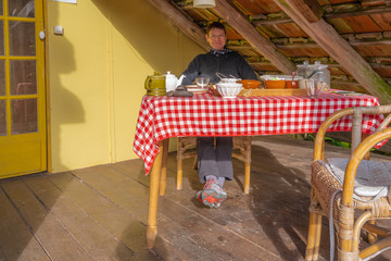 Servance, France - 09 11 2019: A girl sitting with Breakfast at The barns of Montury