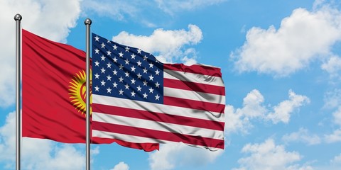 Kyrgyzstan and United States flag waving in the wind against white cloudy blue sky together. Diplomacy concept, international relations.