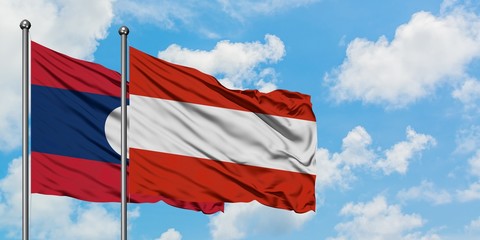 Laos and Austria flag waving in the wind against white cloudy blue sky together. Diplomacy concept, international relations.