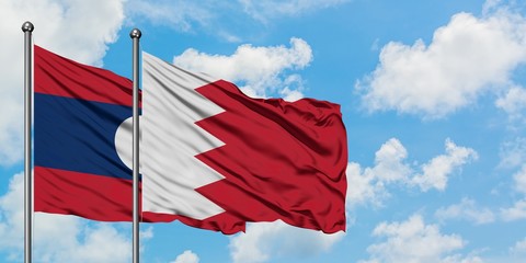 Laos and Bahrain flag waving in the wind against white cloudy blue sky together. Diplomacy concept, international relations.