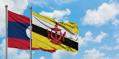 Laos and Brunei flag waving in the wind against white cloudy blue sky together. Diplomacy concept, international relations.