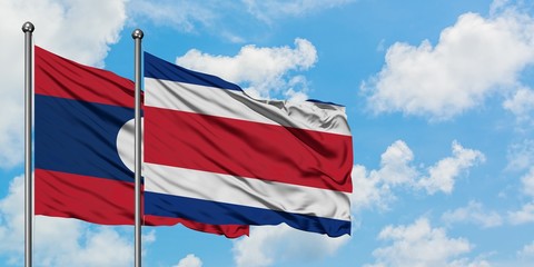 Laos and Costa Rica flag waving in the wind against white cloudy blue sky together. Diplomacy concept, international relations.