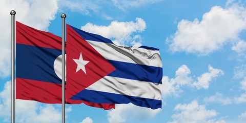 Laos and Cuba flag waving in the wind against white cloudy blue sky together. Diplomacy concept, international relations.