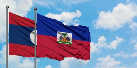 Laos and Haiti flag waving in the wind against white cloudy blue sky together. Diplomacy concept, international relations.