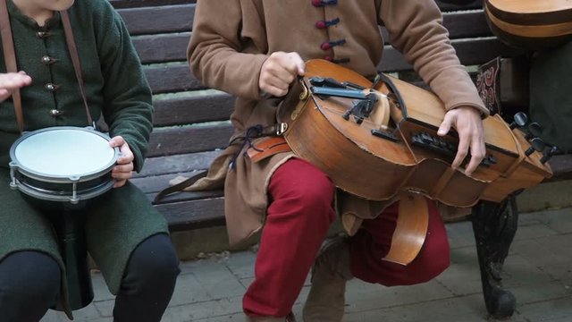 Street musicians dressed in vintage ethnic oriental clothes play music on traditional Middle Eastern musical instruments turkish darbuka and hurdy-gurdy and oud