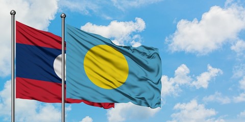 Laos and Palau flag waving in the wind against white cloudy blue sky together. Diplomacy concept, international relations.