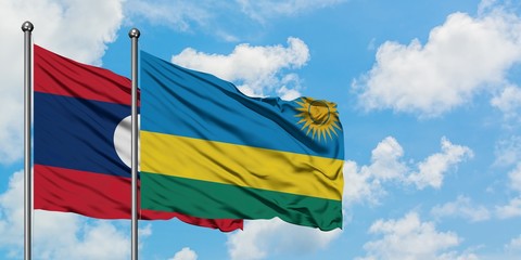 Laos and Rwanda flag waving in the wind against white cloudy blue sky together. Diplomacy concept, international relations.