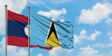 Laos and Saint Lucia flag waving in the wind against white cloudy blue sky together. Diplomacy concept, international relations.