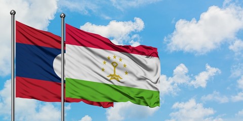 Laos and Tajikistan flag waving in the wind against white cloudy blue sky together. Diplomacy concept, international relations.