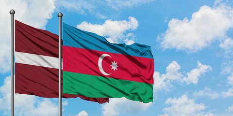 Latvia and Azerbaijan flag waving in the wind against white cloudy blue sky together. Diplomacy concept, international relations.