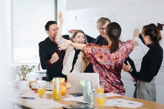 Candid Moment, Happy Coworkers Celebrating The Sucess Of Group Project In The Office. Teamwork  Success Concepts.