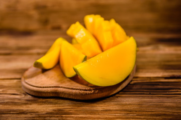 Cutting board with chopped mango fruit on a wooden table